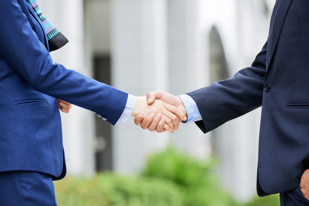 Business professionals shaking hands outdoors
